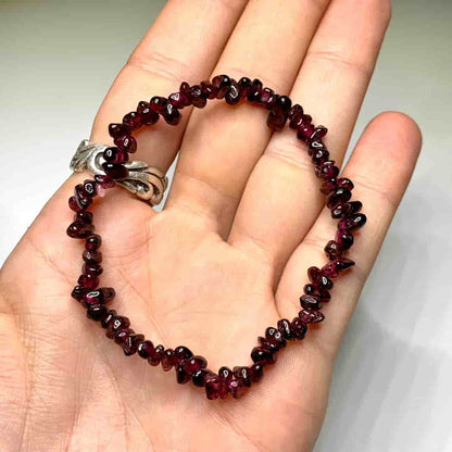 Bracelet baroque chips grenat rouge posé sur la peaume d'une main Kaosix