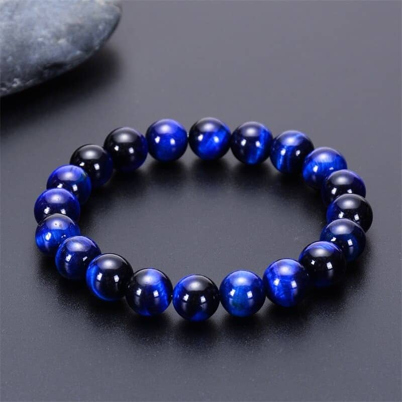 Bracelet confiance en œil de tigre bleu posé sur une table grise Kaosix