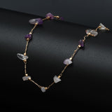 Bracelet de cheville en éclats de pierre d’améthyste et chaînette dorée sur un socle noir Kaosix