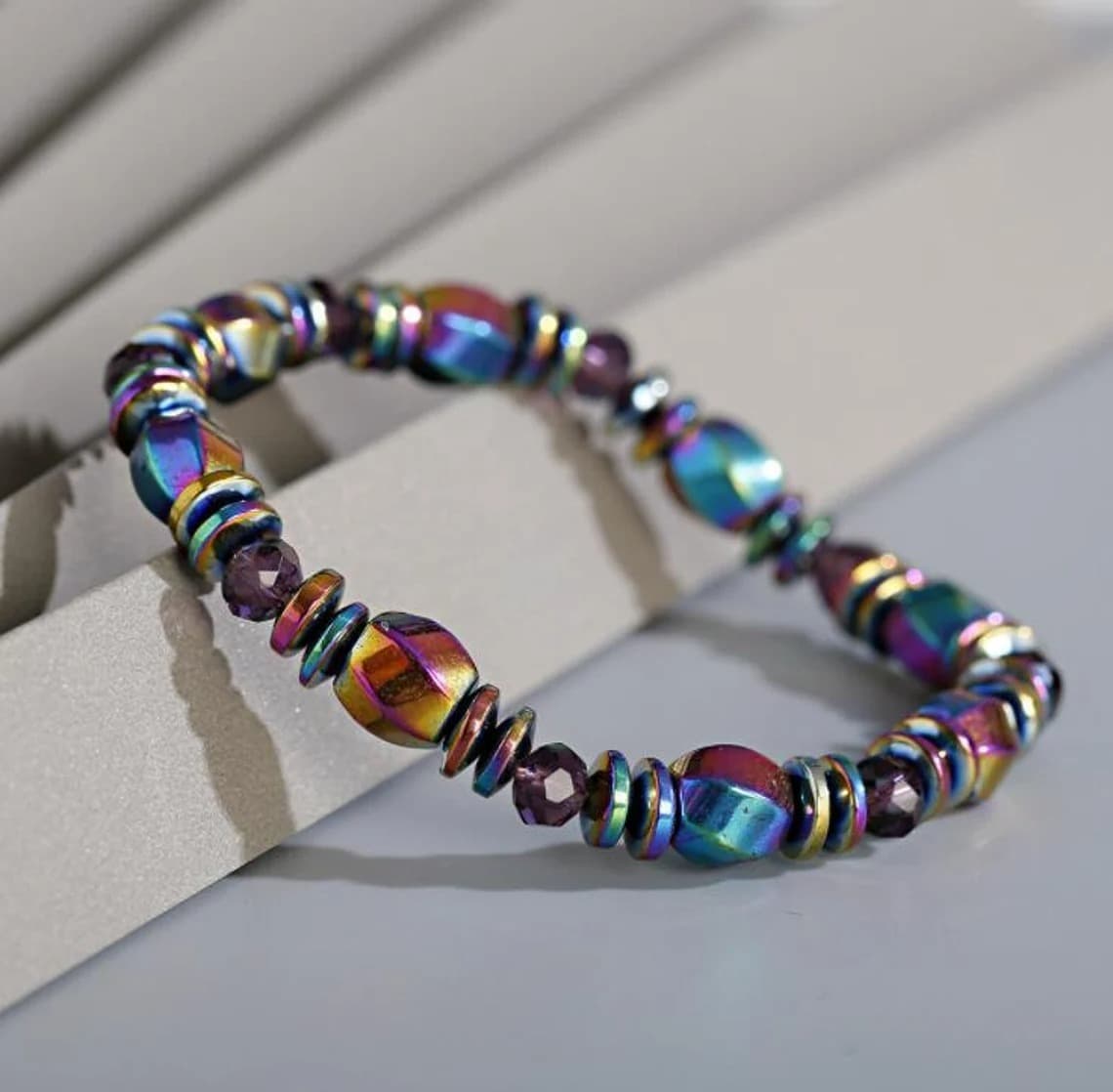 Bracelet en Hématite Arc-en-ciel posé sur un rebord gris et vue en gros plan Kaosix