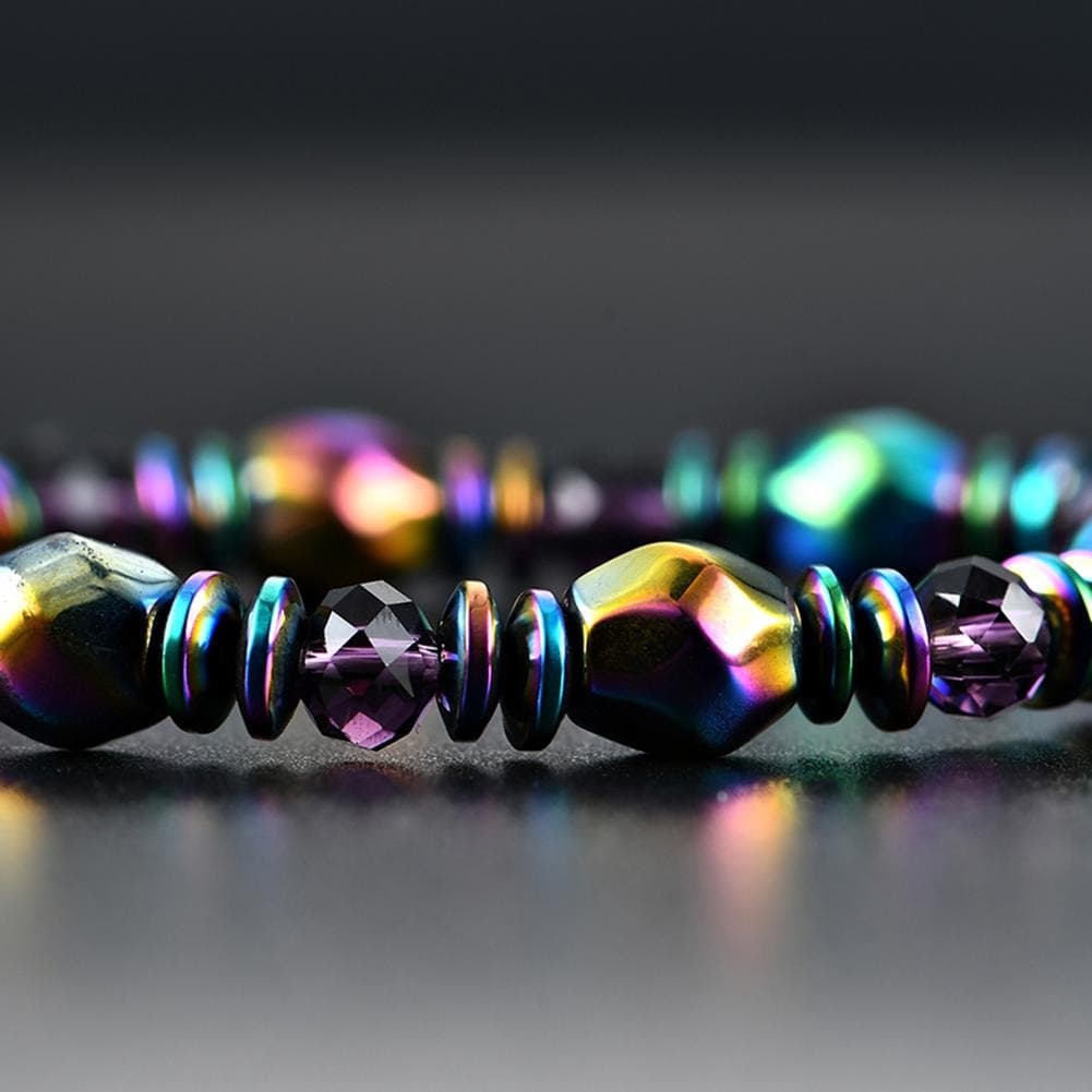 Bracelet en Hématite Arc-en-ciel posé sur un sol gris fonçé brillant et vue en gros plan sur les perles Kaosix
