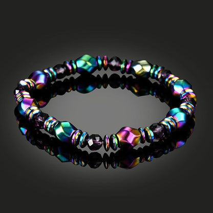 Bracelet en Hématite Arc-en-ciel posé sur un sol noir brillant Kaosix