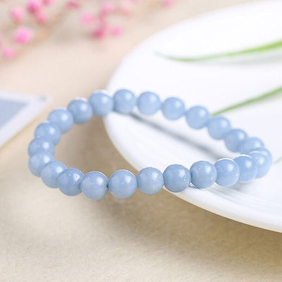 Bracelet en angélite apaisement boule 8 mm posé sur une assiette blanche Kaosix