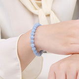 Bracelet en angélite apaisement boule 8 mm sur le poignet d'une jeune femme Kaosix