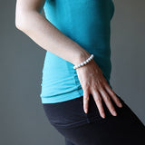 Bracelet en howlite calme boule 8 mm sur un poignet de femme avec le bras le long de son corps Kaosix