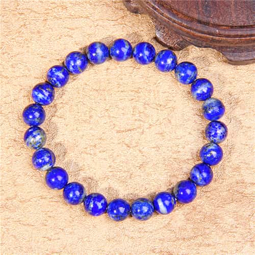 Bracelet en lapis lazuli vérité vue de haut posé sur une moquette blanche Kaosix