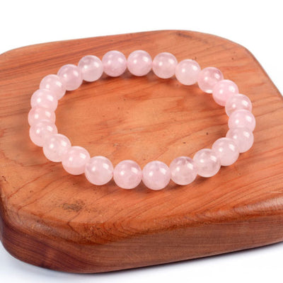 Bracelet en quartz rose amour boule 8 mm sur une planche en bois Kaosix