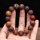 Bracelet feng shui Pi Xiu en perles de bois colorées sur les doigts d'une main Kaosix