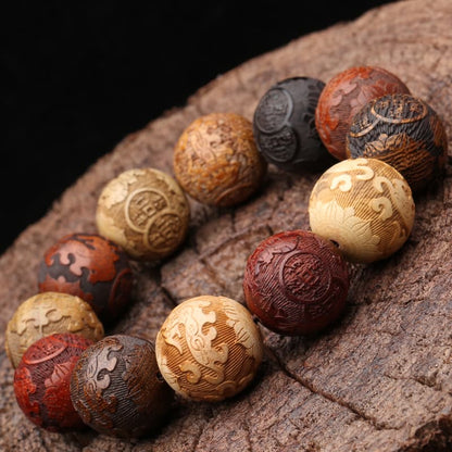 Bracelet feng shui Pi Xiu en perles de bois colorées sur un trond d'arbre scié Kaosix
