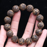 Bracelet feng shui Pi Xiu en perles de bois dorées sur les doigts d'une main Kaosix
