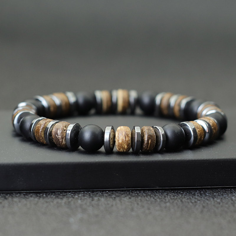 Bracelet homme onyx noir hématite bois de cocotier sur un socle noir Kaosix