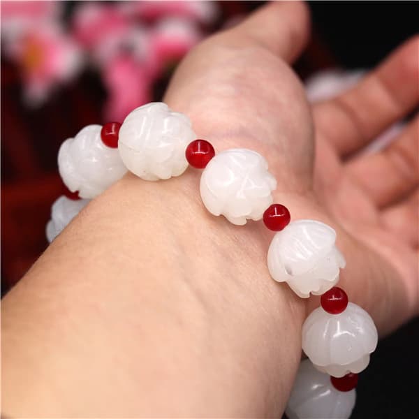 Bracelet jade blanc lotus au poignet d'une femme Kaosix
