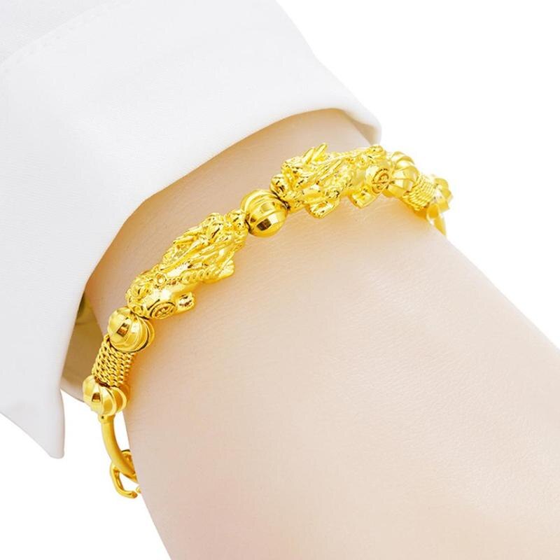 Bracelet jonc doré double Pi Xiu sur un poignet de jeune fille en gros plan Kaosix