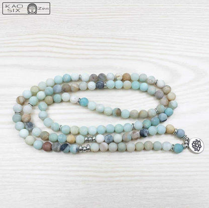 Bracelet mala 108 perles amazonite lotus déroulé sur plancher en bois clair Kaosix