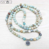 Bracelet mala 108 perles amazonite lotus sur plancher bois Kaosix
