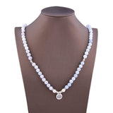 Bracelet mala 108 perles en aigue-marine avec symbole du lotus posé autour du coup et des épaules d'un buste mannequin Kaosix