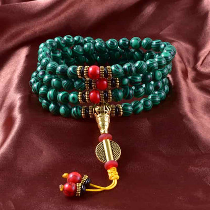 Bracelet mala 108 perles en malachite empilé sur une nape soyeuse Kaosix