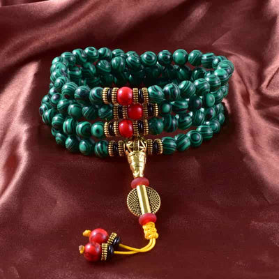 Bracelet mala 108 perles en malachite empilé sur une nape soyeuse Kaosix