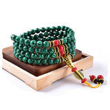 Bracelet mala 108 perles en malachite sur fond blanc avec cadre orange Kaosix