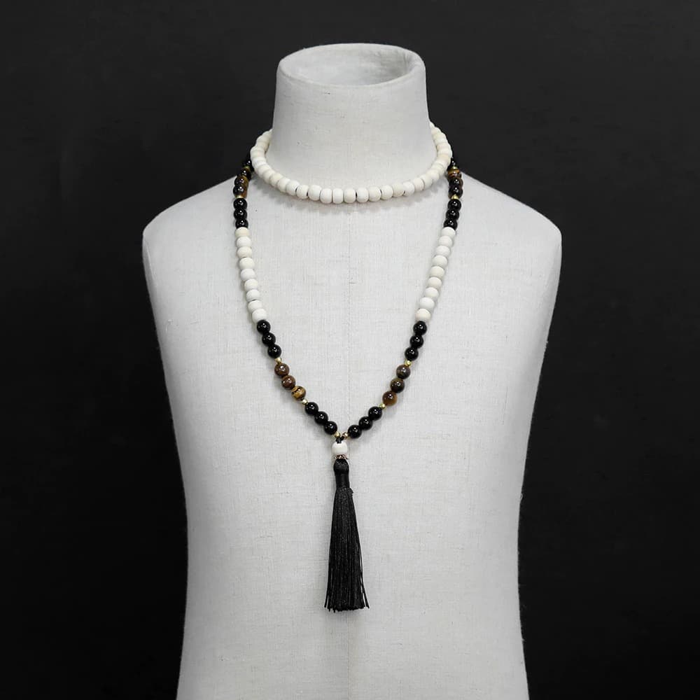 Bracelet mala 108 perles en œil de tigre et en bois sur un buste de mannequin blanc et fond noir Kaosix
