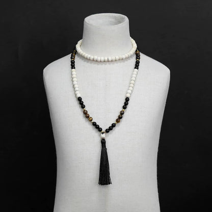Bracelet mala 108 perles en œil de tigre et en bois sur un buste de mannequin blanc et fond noir Kaosix