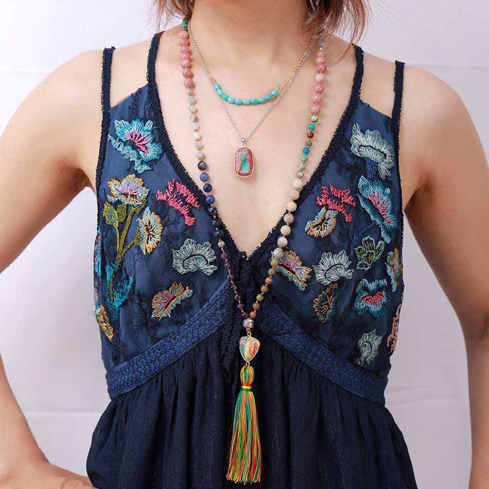 Bracelet mala 108 perles jaspe turquoise améthyste rhodonite posé autour du cou d'une femme Kaosix
