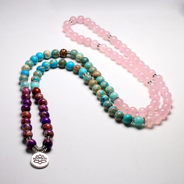 Bracelet mala 108 perles quartz rose amazonite jaspe turquoise posé sur un sol gris Kaosix