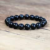 Bracelet obsidienne noire “stabilité” sur sol en bois clair Kaosix