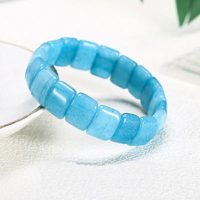 Bracelet pierres plates (plaquettes) aigue marine posé sur le rebord d'une assiette Kaosix