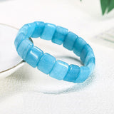Bracelet pierres plates (plaquettes) aigue marine posé sur le rebord d'une assiette Kaosix