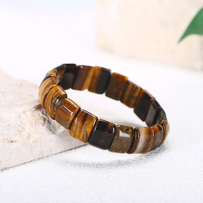 Bracelet pierres plates (plaquettes) œil de tigre posé à moitié sur une pierre plate Kaosix
