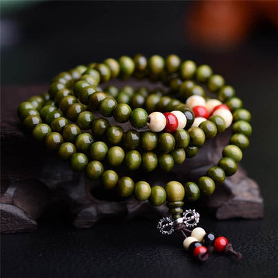 Bracelets mala de prière en bois de santal colour vert 108 perles posé sur un socle en bois Kaosix.