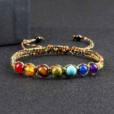 Bracelet tibétain 7 chakras macramé posé sur une surface grise Kaosix