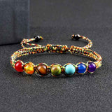 Bracelet tibétain 7 chakras macramé posé sur une surface grise Kaosix
