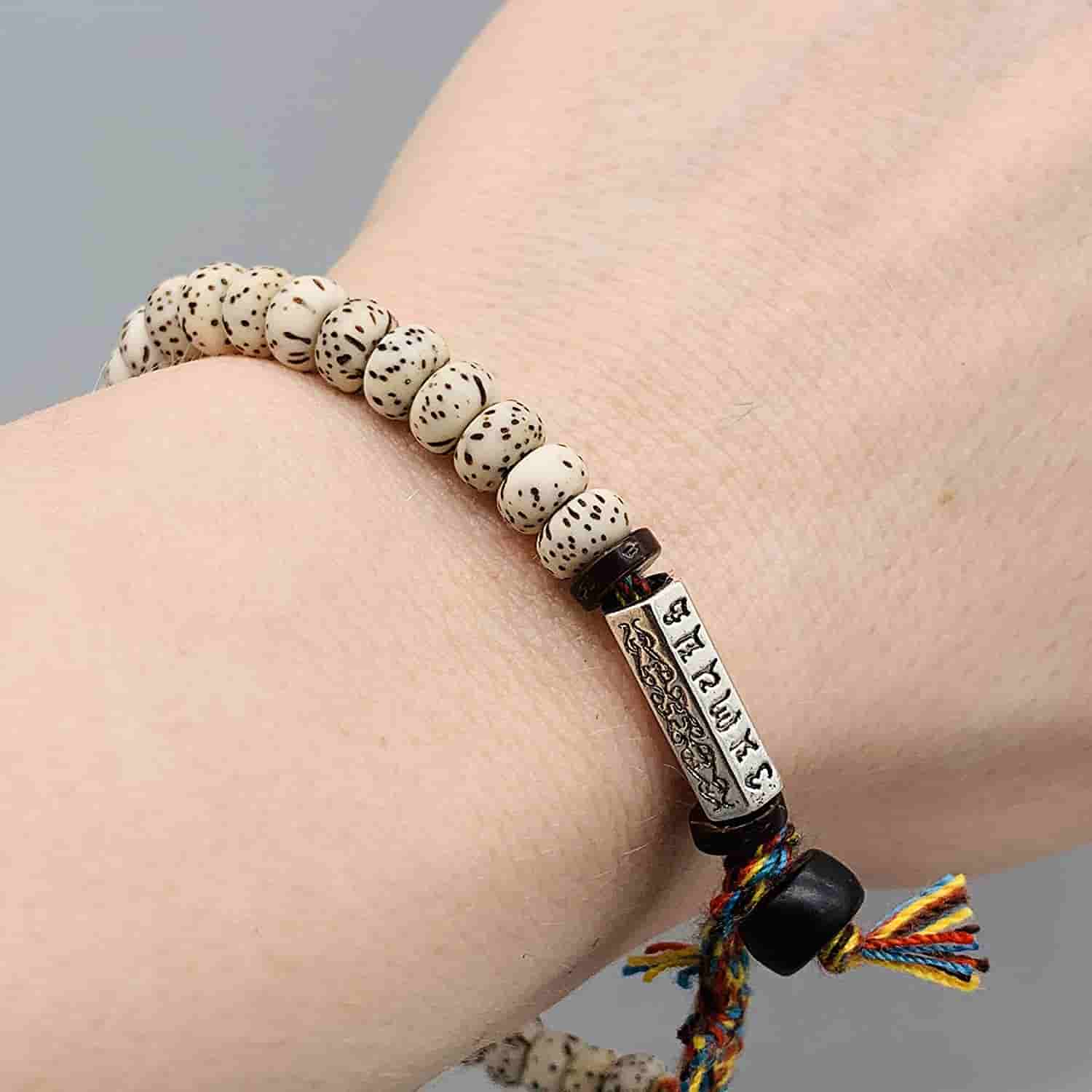 Bracelet tibétain graine de bodhi mantra avec amulette Om sur poignet de jeune femme Kaosix