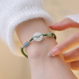 Bracelet tressé perles et anneau blanc en jade de Hetian au poignet d'une jeune fille Kaosix