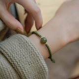 Bracelet tressé perles vertes en jade de Hetian au poignet d'une jeune fille Kaosix