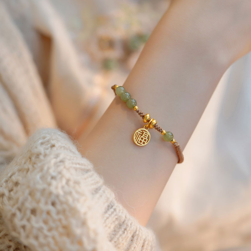 Bracelet tressé perles vertes en jade de Hetian et amulette dorée au bras d'une jeune fille Kaosix