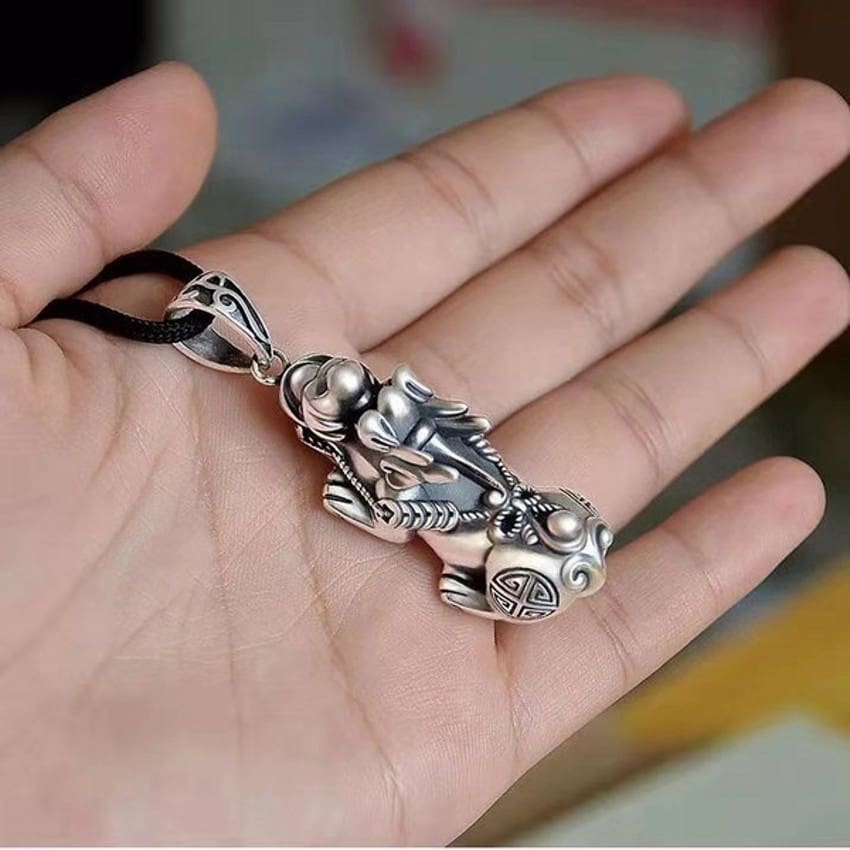 Collier Pendentif Feng Shui Pi Xiu Chance et Protection posé sur la peaume de la main d'une femme Kaosix