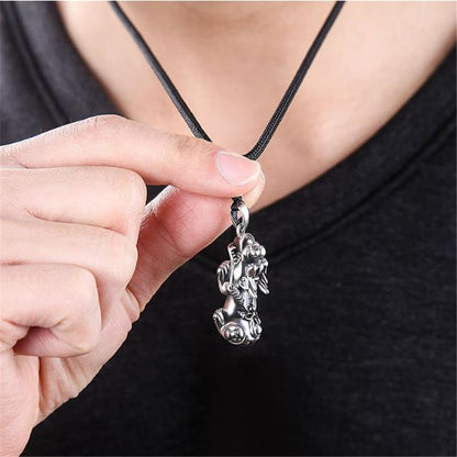 Collier Pendentif Feng Shui Pi Xiu Chance et Protection tenu entre les doigts d'une femme Kaosix