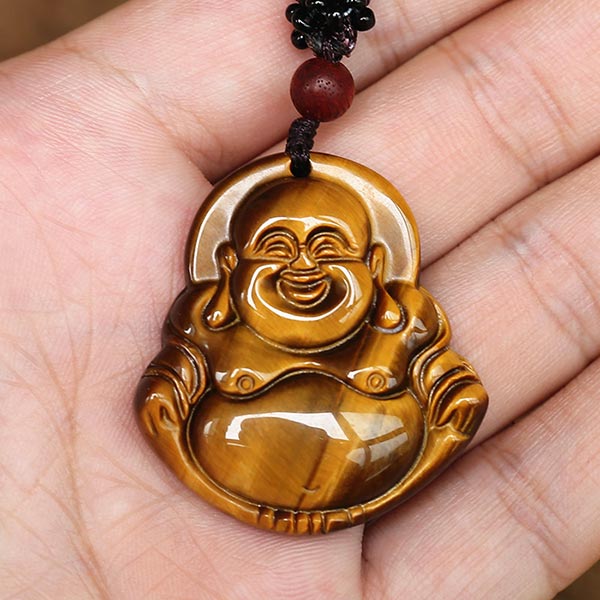 Collier pendentif Bouddha Rieur en Œil de Tigre posé sur la peaume d'une main d'homme Kaosix