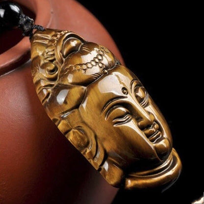 Collier pendentif Guanyin (Bouddha) en Œil de Tigre posé contre une théière rouge Kaosix