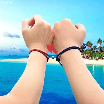 Deux bracelets couple cordon rouge et noir sur les bras respectifs dun couple Kaosix