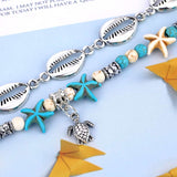 Gro plan sur l'amulette de la tortue de mer du Bracelet de cheville en coquillages cauris étoiles de mer avec amulette tortue de mer Kaosix