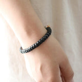 Gros plan du bracelet tibétain coquille de coco mantra sur le poignet d'une femme Kaosix