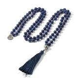 Mala 108 perles Lapis Lazuli et symbole arbre de vie déroulé sur un sol blanc Kaosix