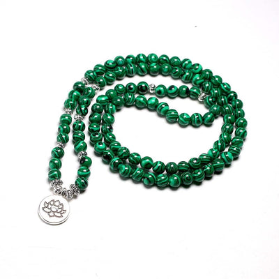 Mala 108 perles Malachite et symbole du Lotus (boule 6 mm) enroulé sur un sol blanc Kaosix