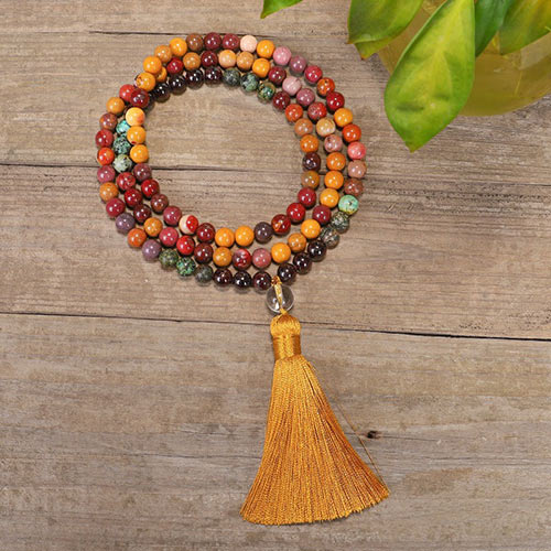 Mala 108 perles Obsidienne Acajou, Jaspe Mokaite, Turquoise Africaine enroulé et posé sur un plancher en bois Kaosix