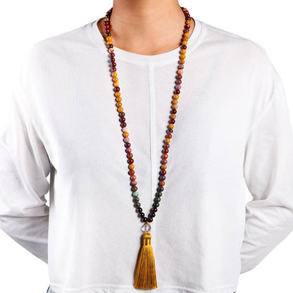 Mala 108 perles Obsidienne Acajou, Jaspe Mokaite, Turquoise Africaine suspendu au coup d'un homme en chemise blanche Kaosix