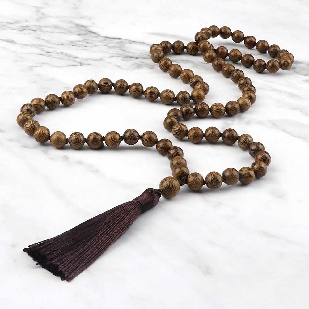 Mala 108 perles bois de santal avec pompon vue de côté posé sur une plaque de marbre gris et blanc Kaosix